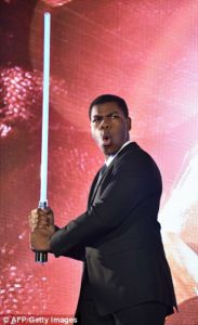 John Boyega with lightsaber promoting star wars